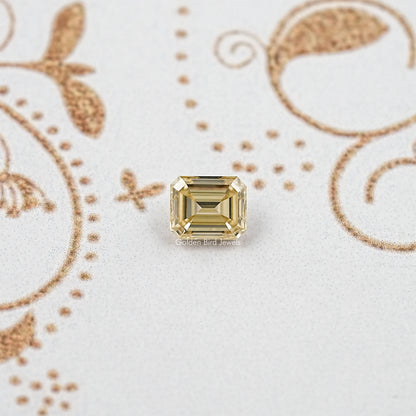 Yellow emerald-cut moissanite gemstone with square step facets, front view centerpiece.