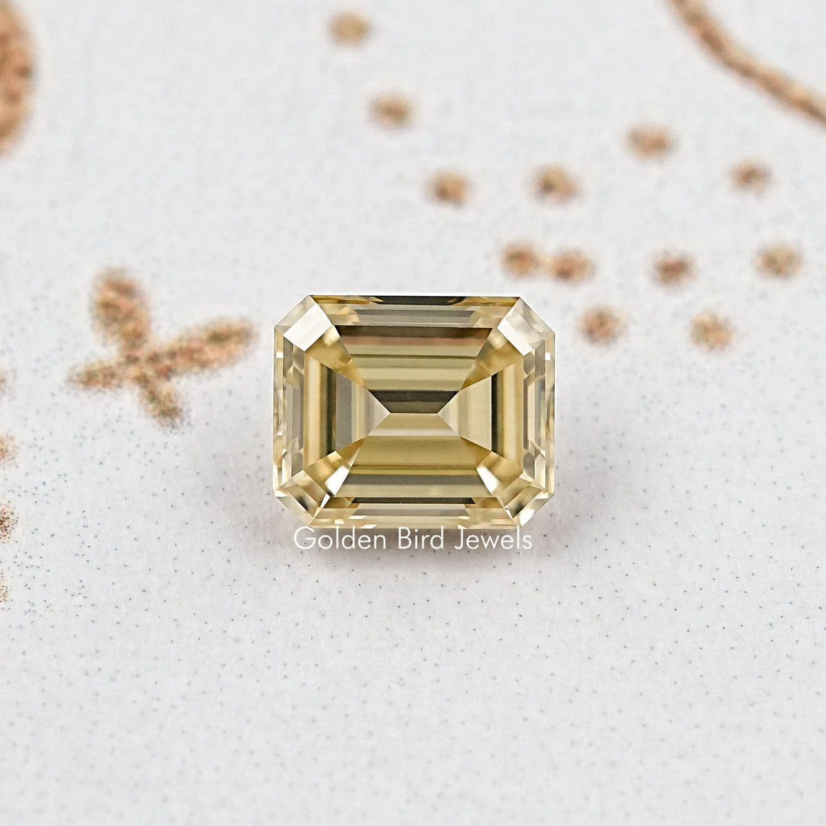 Yellow emerald-cut moissanite gemstone showing step facets and crisp edges, front view.