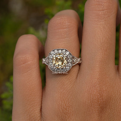 Sterling silver cushion halo ring on hand with round yellow center stone