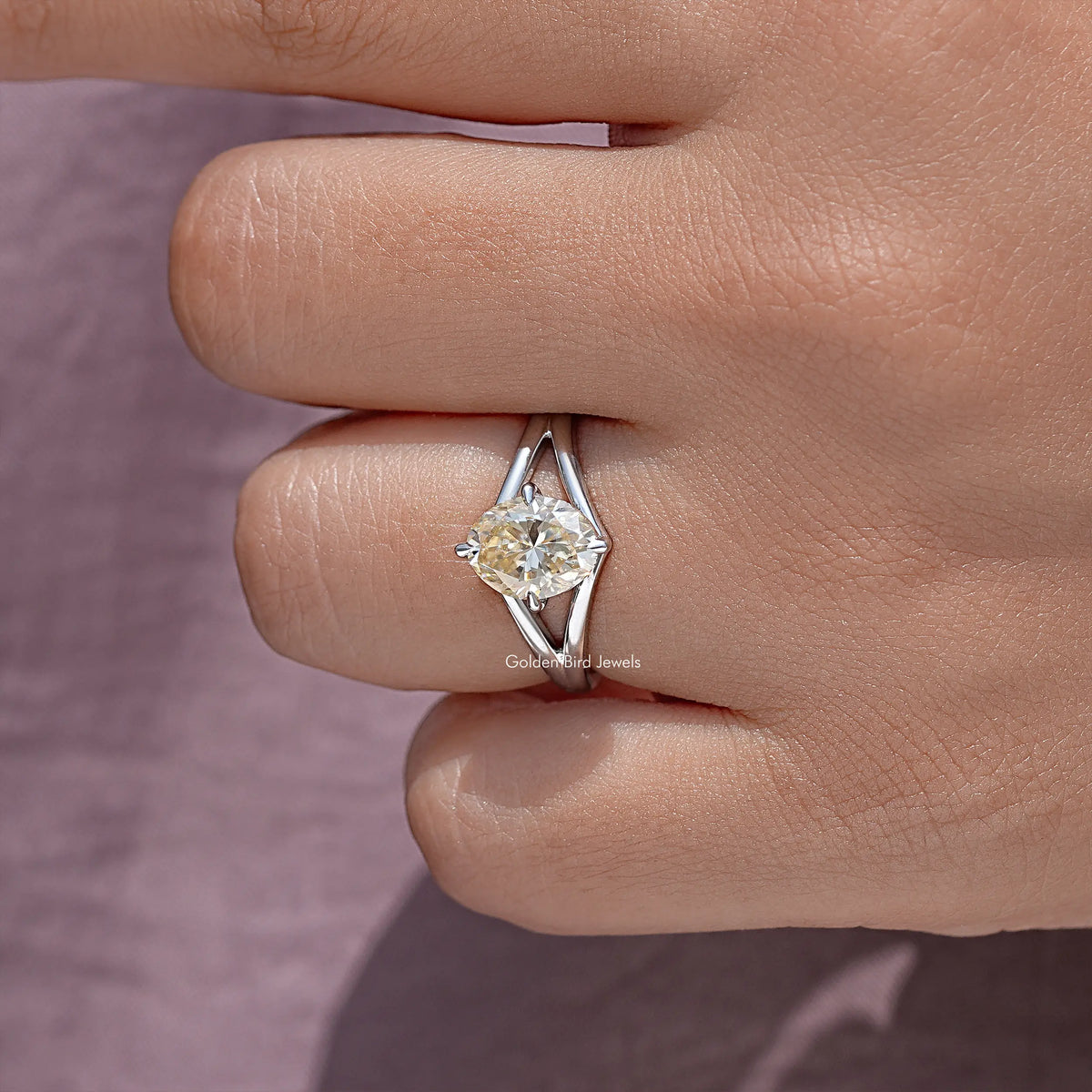 Oval moissanite split-shank engagement ring, close-up of prong-set oval center