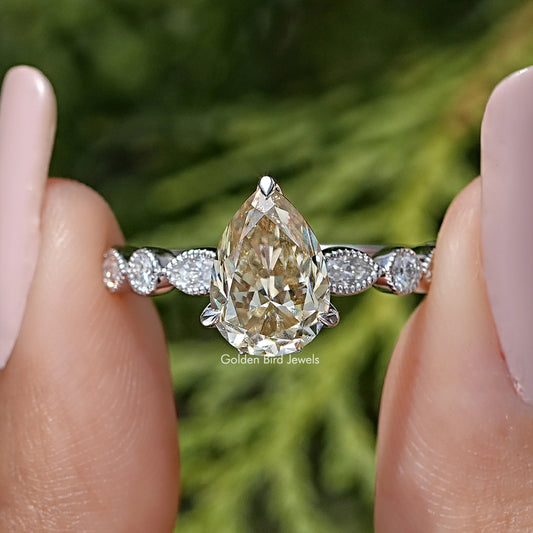 Sterling silver engagement ring with yellow pear-cut moissanite center and side stones