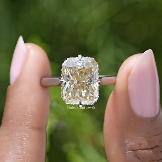 Yellow radiant-cut moissanite engagement ring with square center stone and metal prongs
