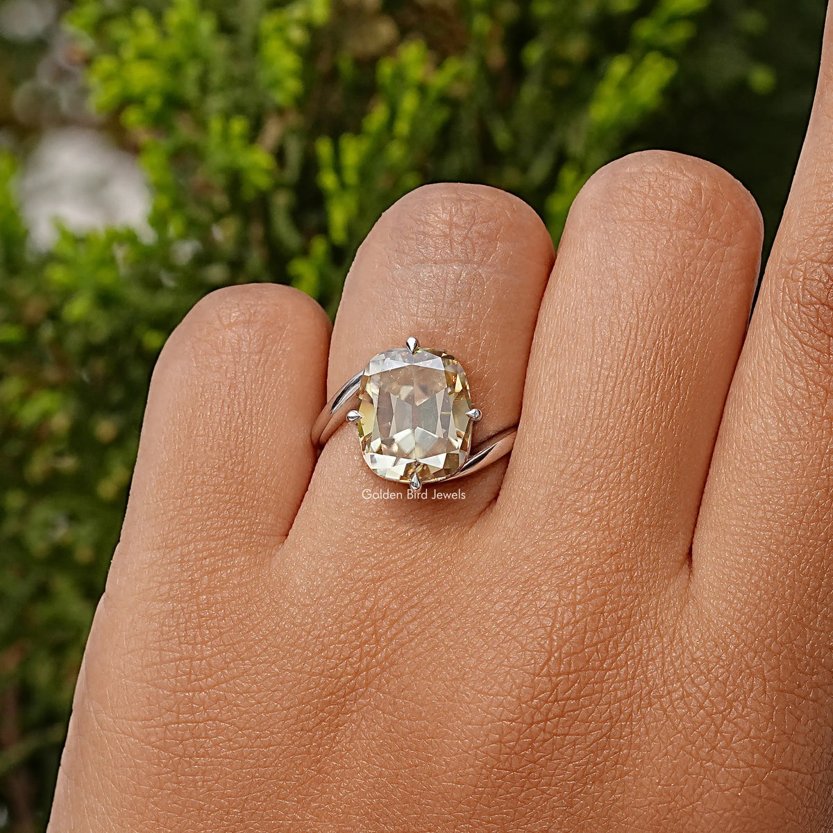Clear cushion-cut moissanite solitaire ring in sterling silver, worn on hand