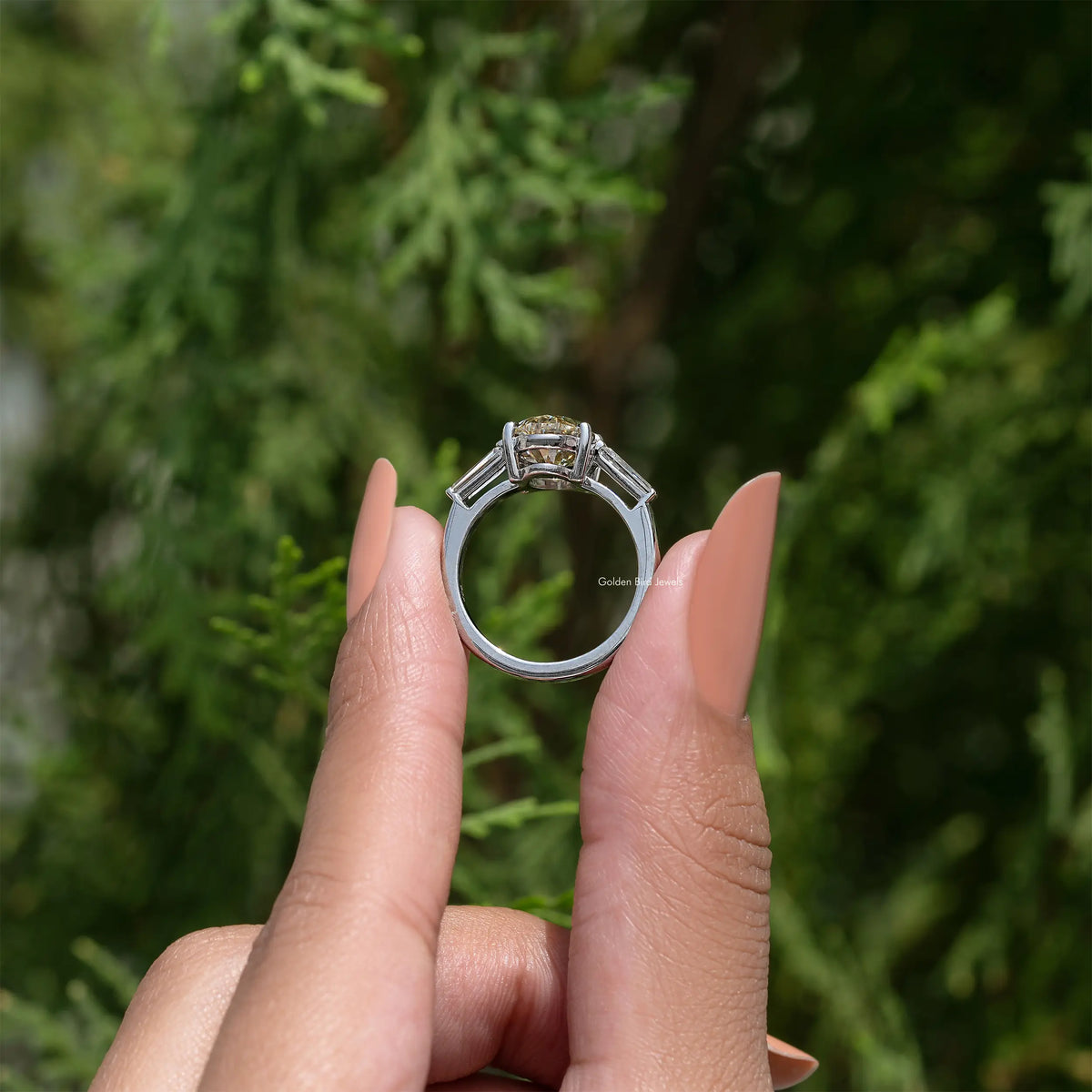 Back view of sterling silver three-stone ring with prong-set oval yellow moissanite