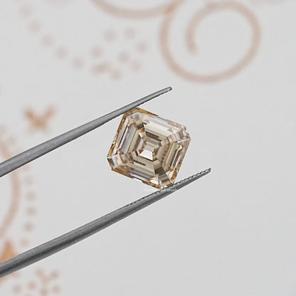 Loose yellow moissanite gemstone, Old Mine Asscher cut held in tweezers