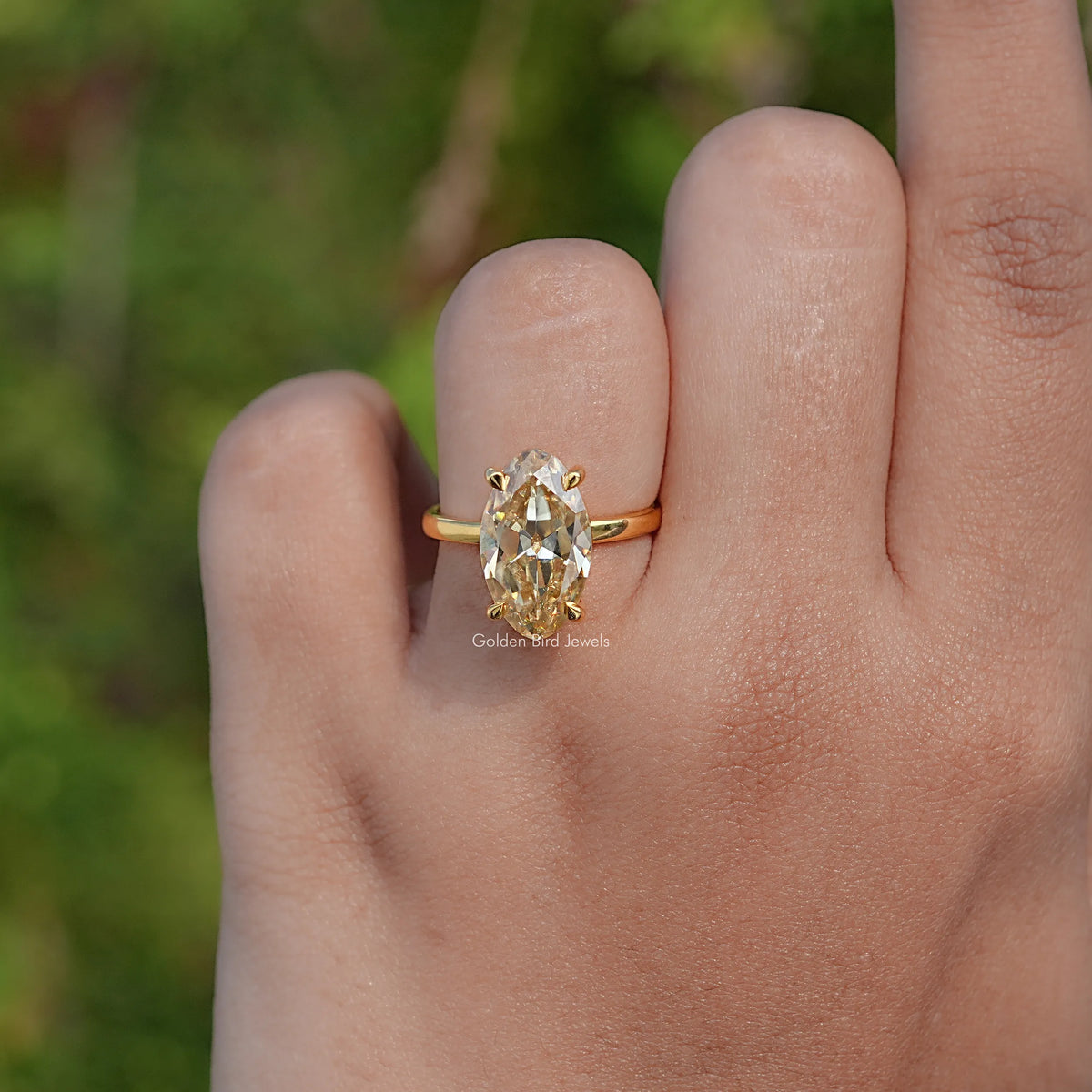 Gold-tone oval moissanite solitaire ring, thin band with oval center stone