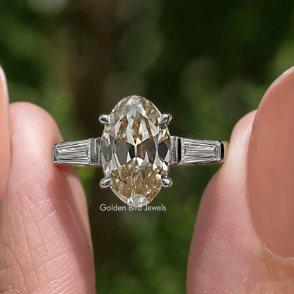Close-up: sterling silver three-stone ring with oval yellow moissanite and baguette sides
